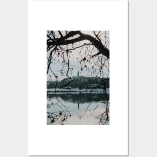 Branches of trees in front of church tower with river bank. Posters and Art